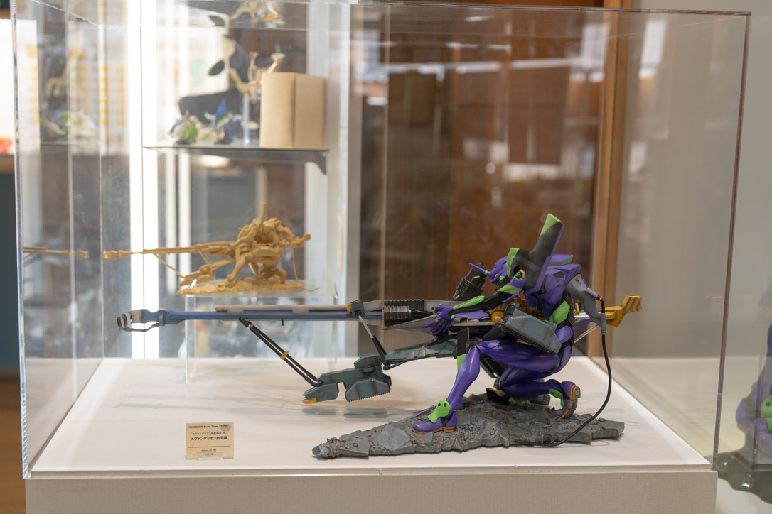 Evangelion Unit 01 action figure with sniper rifle pose at Kaiyodo Hobby Museum