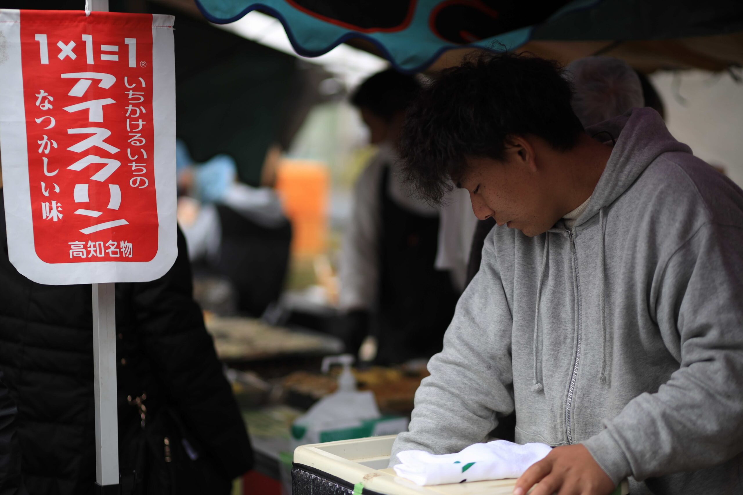 Tosa Miyabi knife vendor at Kochi Sunday Market browsing handcrafted Tosa knives