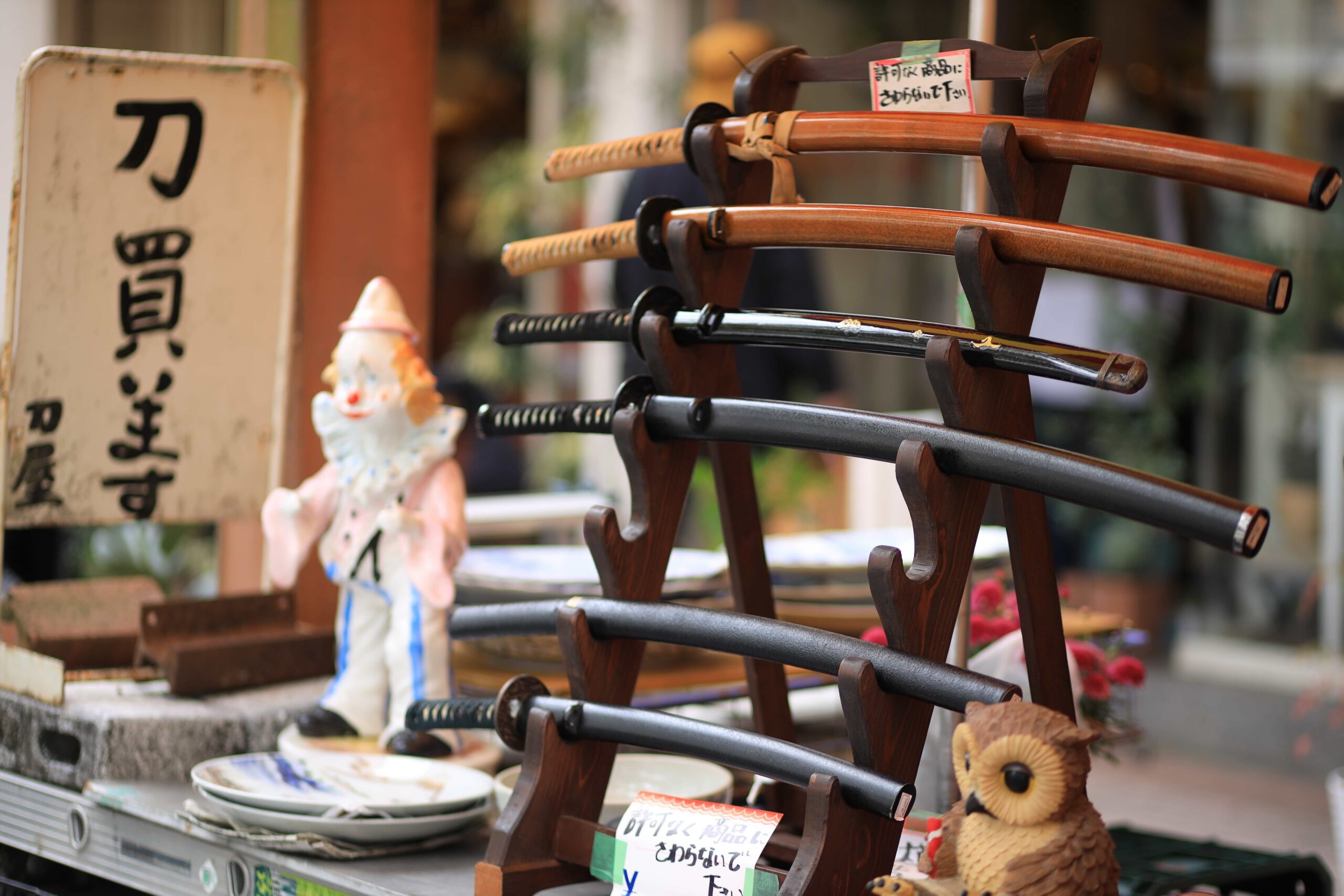 Antique katana swords displayed on wooden stands at Kochi Sunday Market