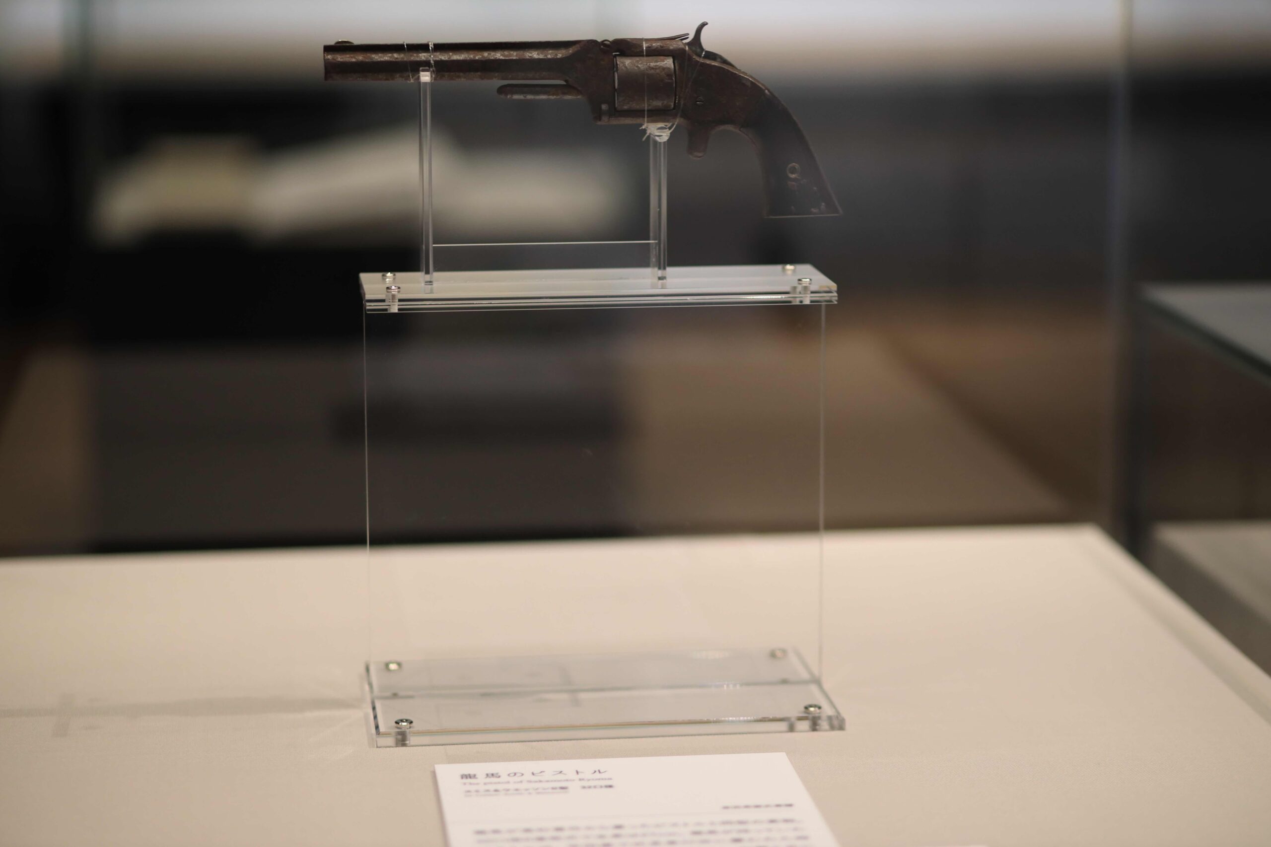 Display case showing Ryoma's black formal kimono, English alphabet scroll, and traditional instruments