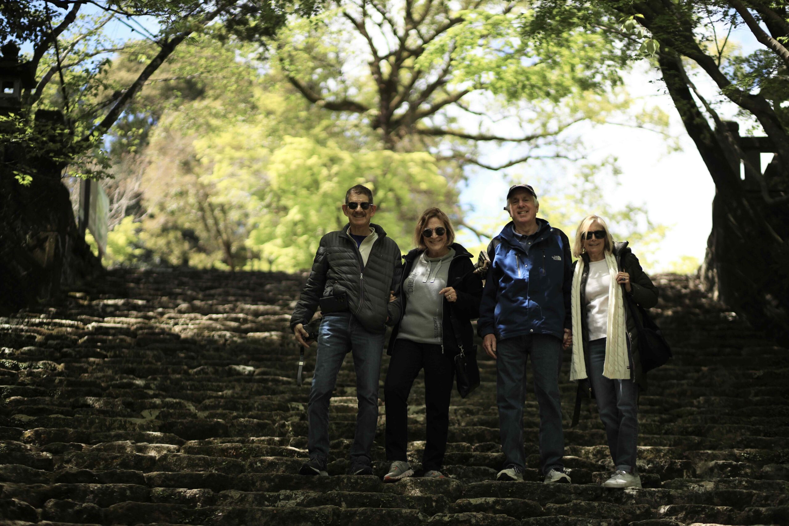 Guests sitting on the wooden bench at Makino Botanical Garden surrounded by spring flowers