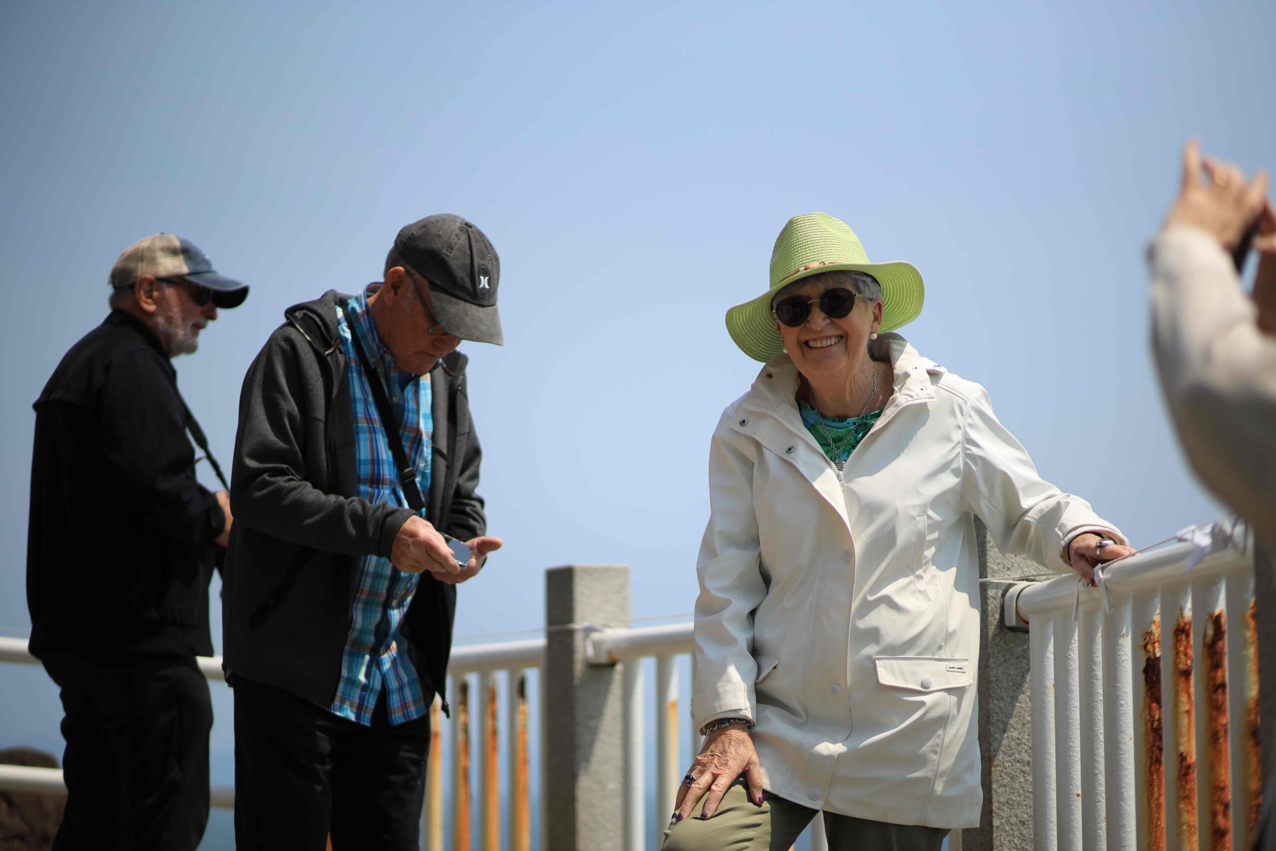 Group photo on Katsurahama Beach dark sand with pine-covered headland behind
