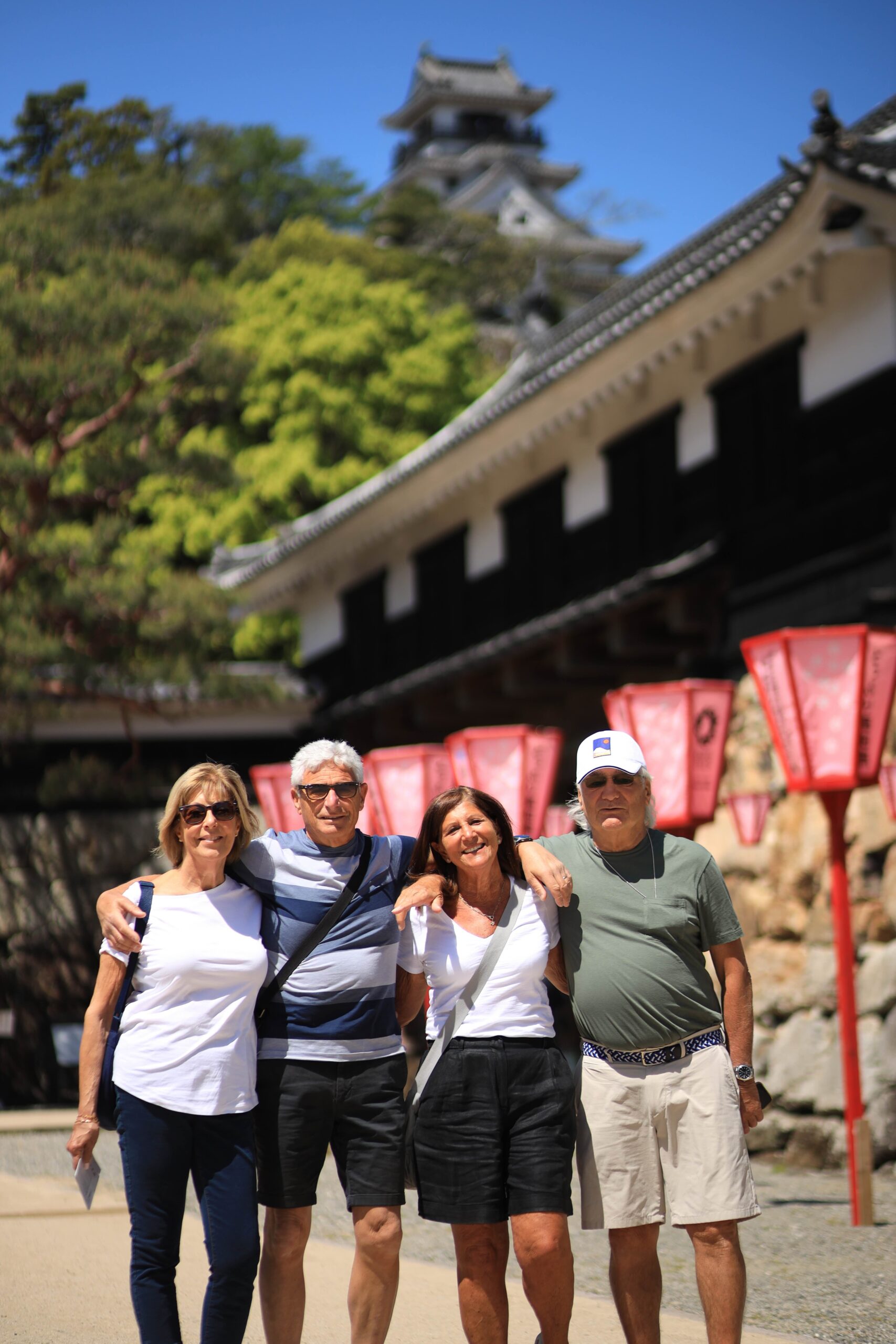 Tour guests at Kochi Castle entrance with red lanterns in spring