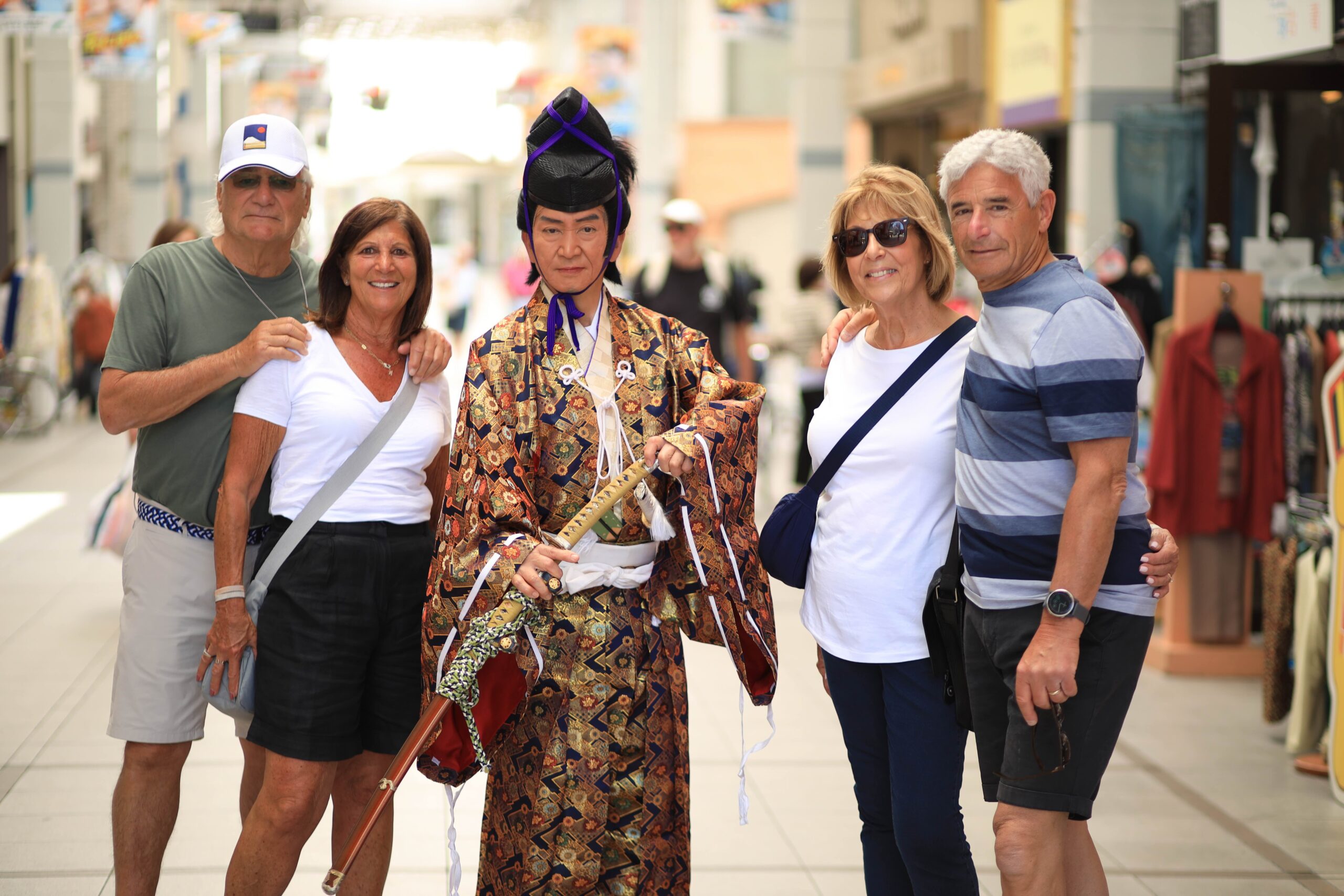 Tour guests posing with samurai costumed performer in Obiyamachi covered shopping arcade Kochi