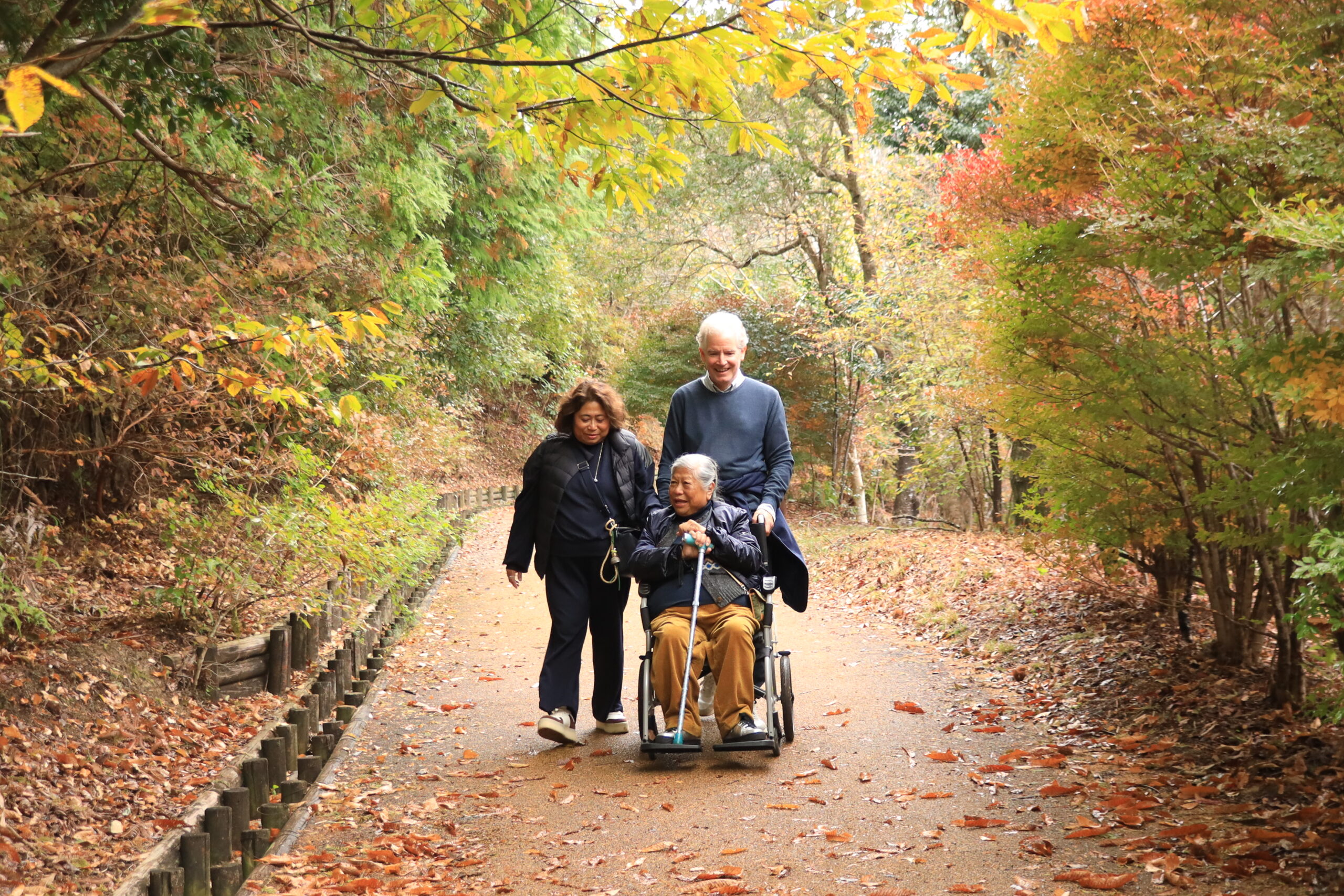 Family walking through autumn garden path