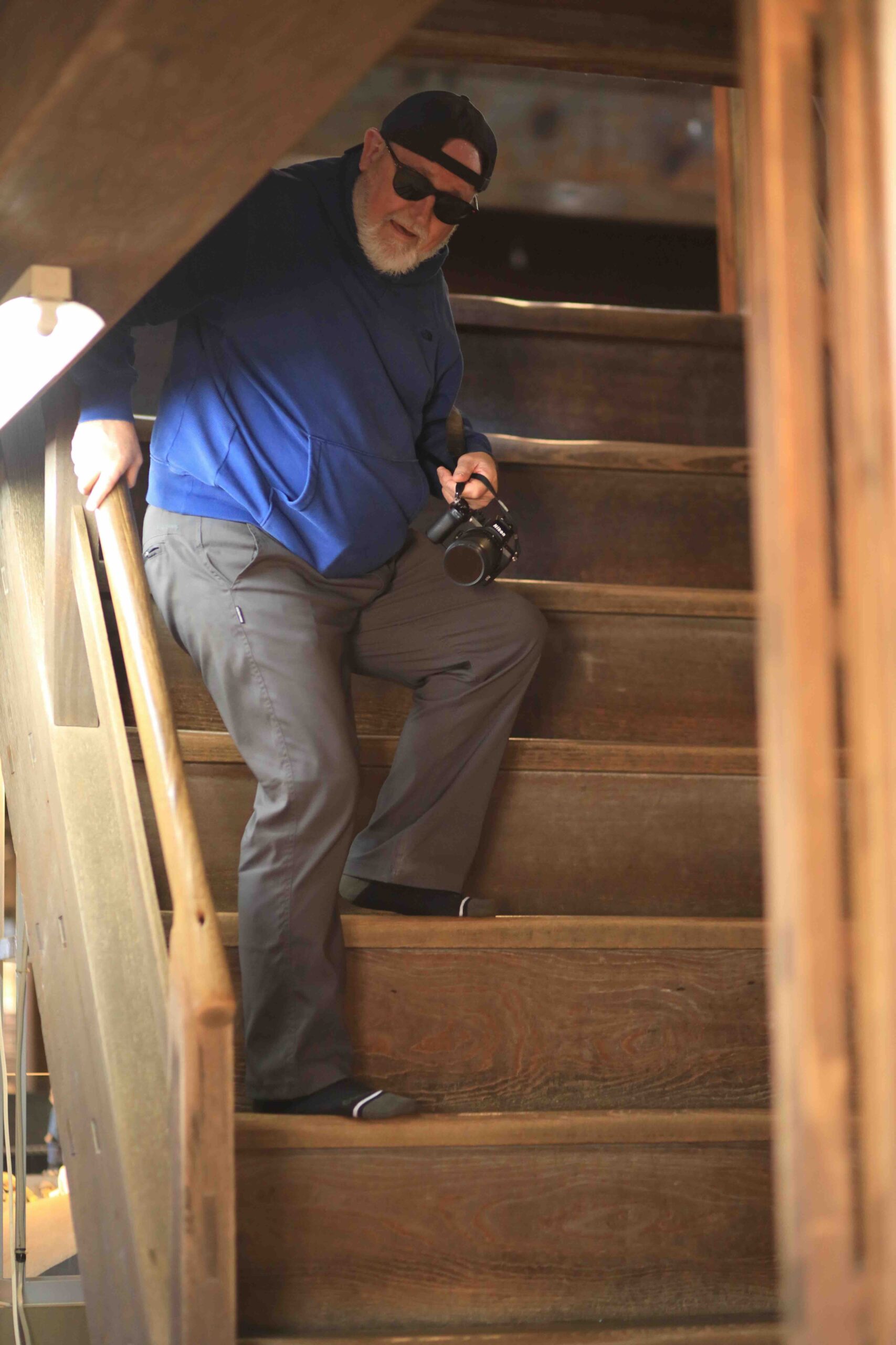 Visitor descending steep original wooden staircase inside Kochi Castle