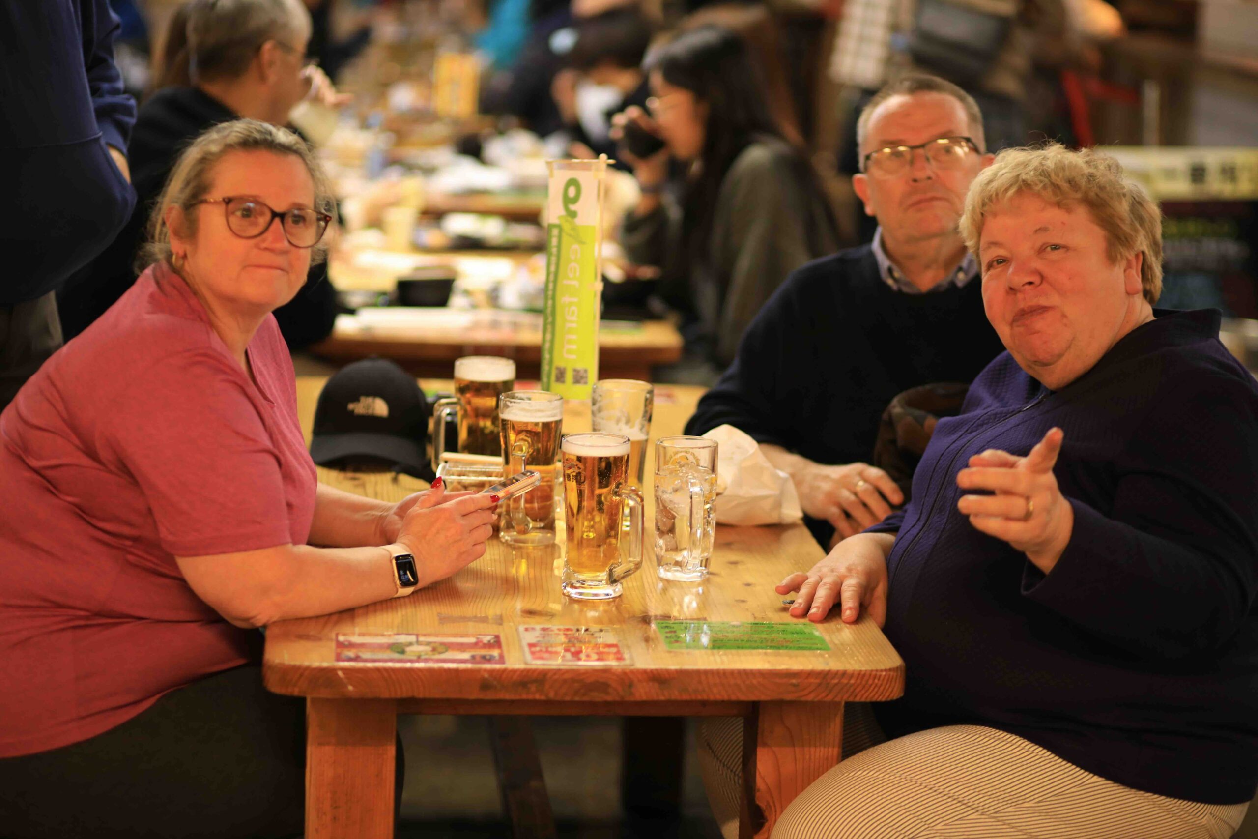 Tour guests enjoying local beer and food at communal tables inside Hirome Market Kochi
