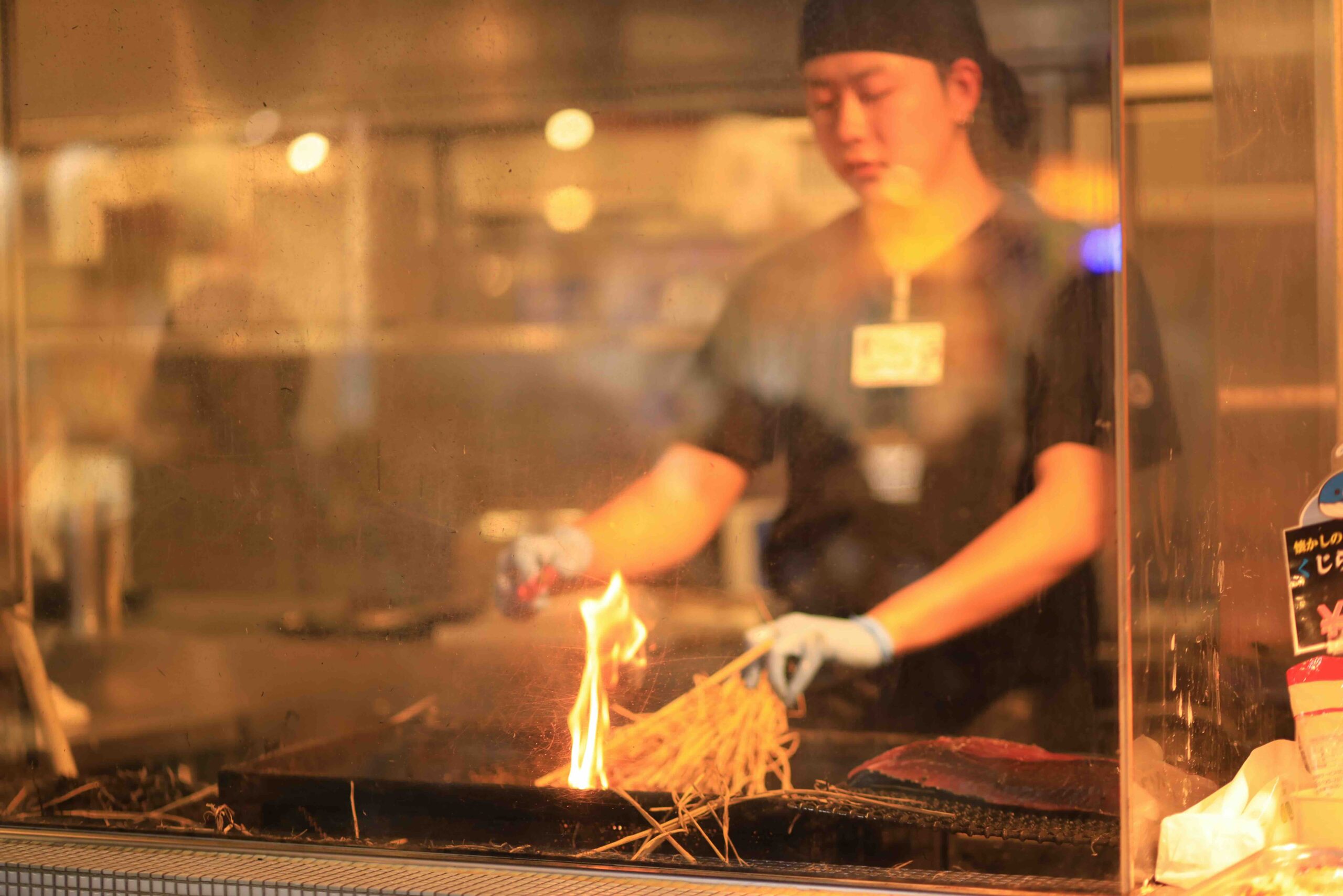 Chef searing katsuo no tataki over straw fire at Hirome Market in Kochi