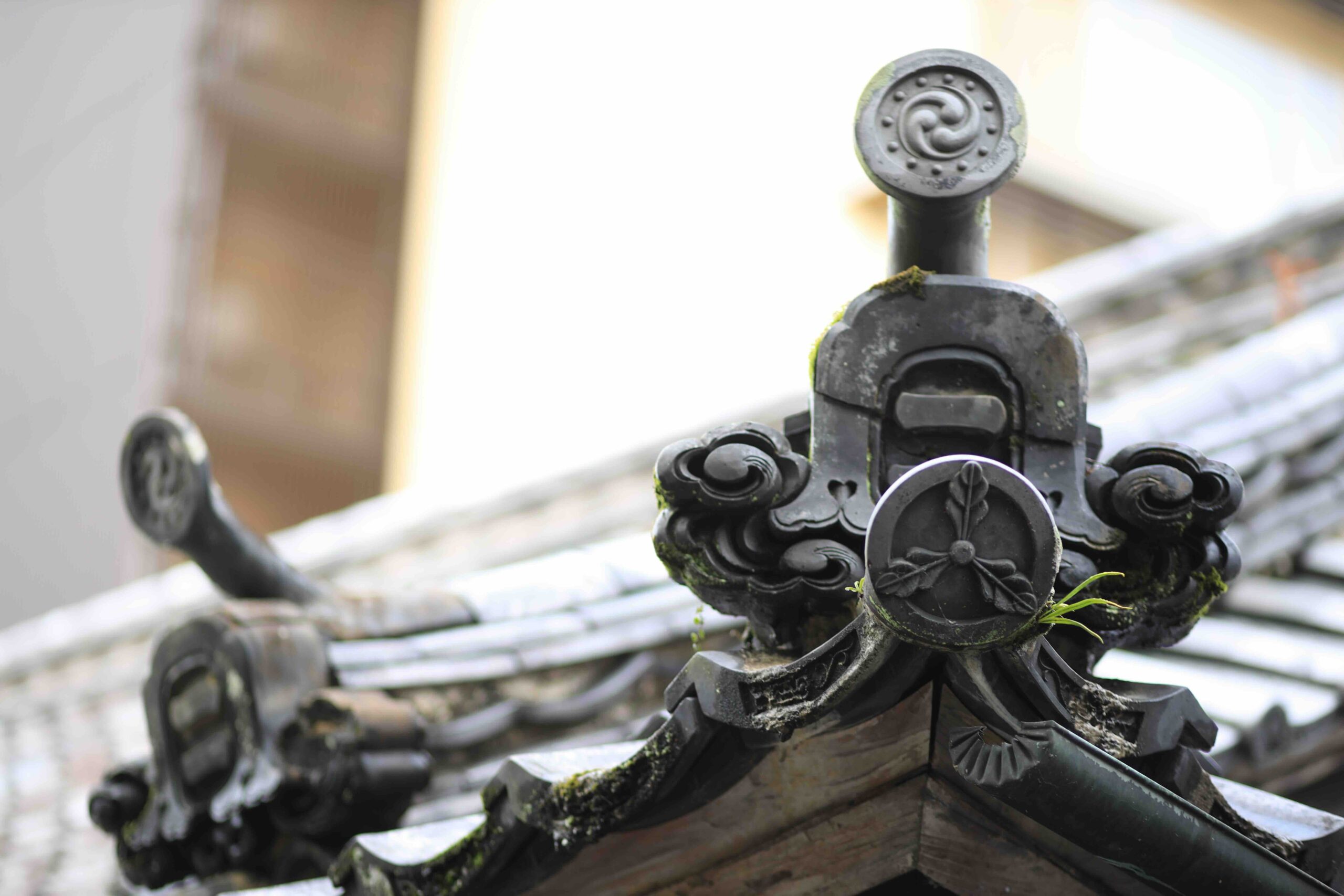 Ornate decorative roof tiles with family crest on the Kyu Yamauchi-ke Shimoyashiki Nagaya Exhibition Hall at Sansuien