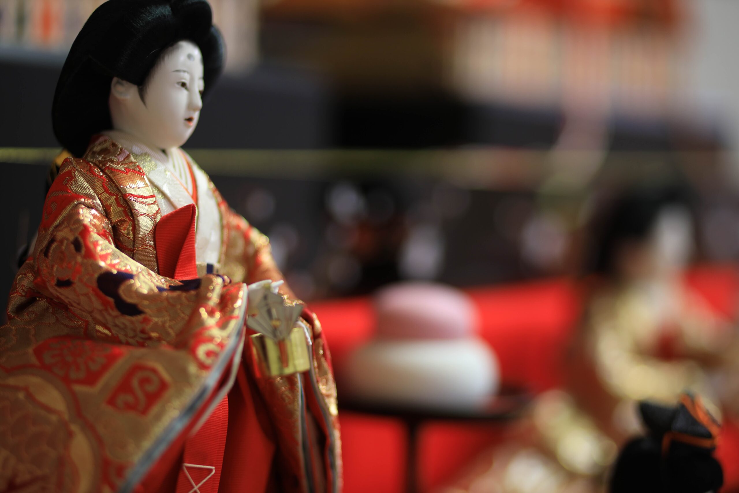 Close-up of the female Ohina-sama doll in red and gold court kimono