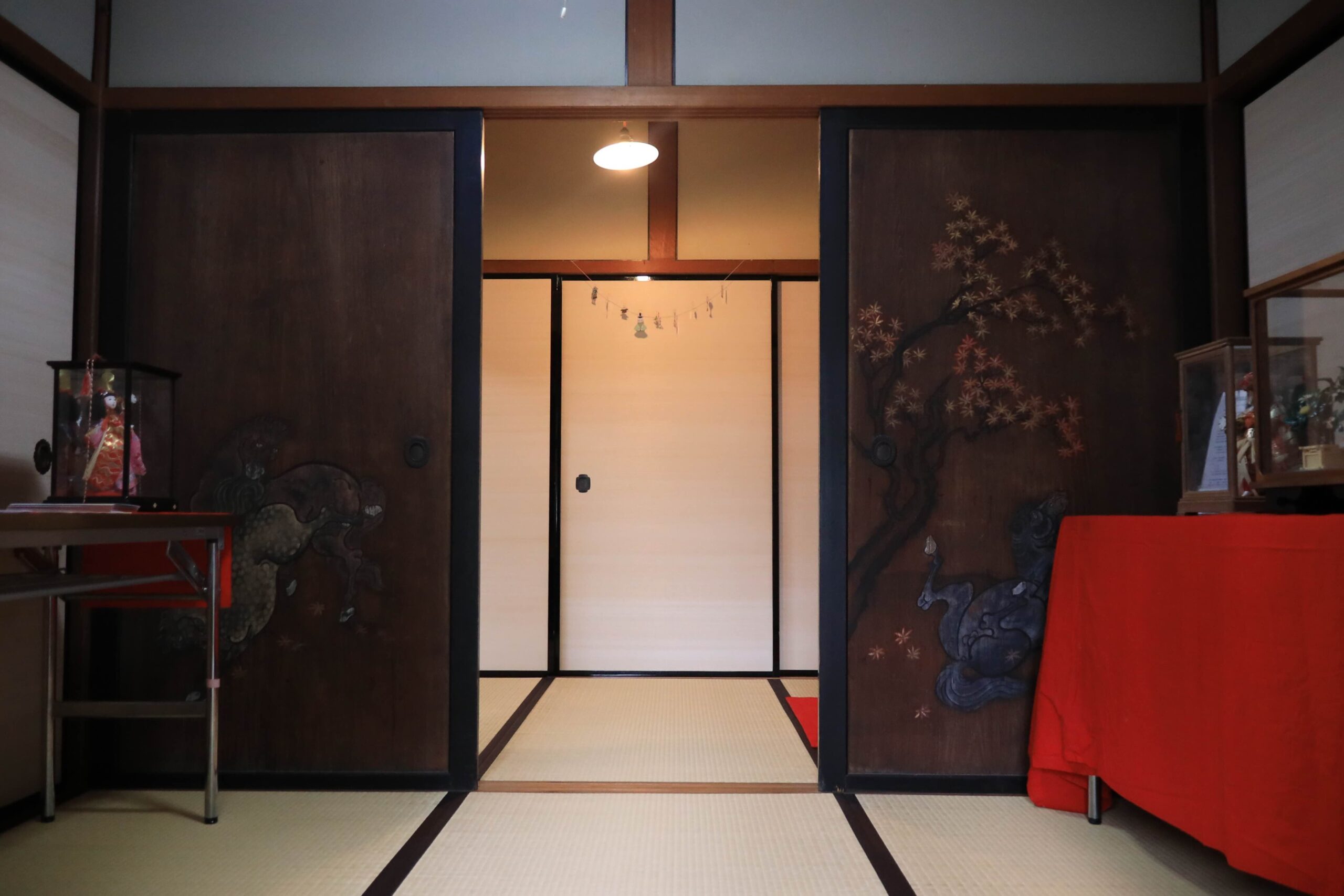 Traditional Japanese room with beautifully painted fusuma sliding doors featuring pine and maple designs