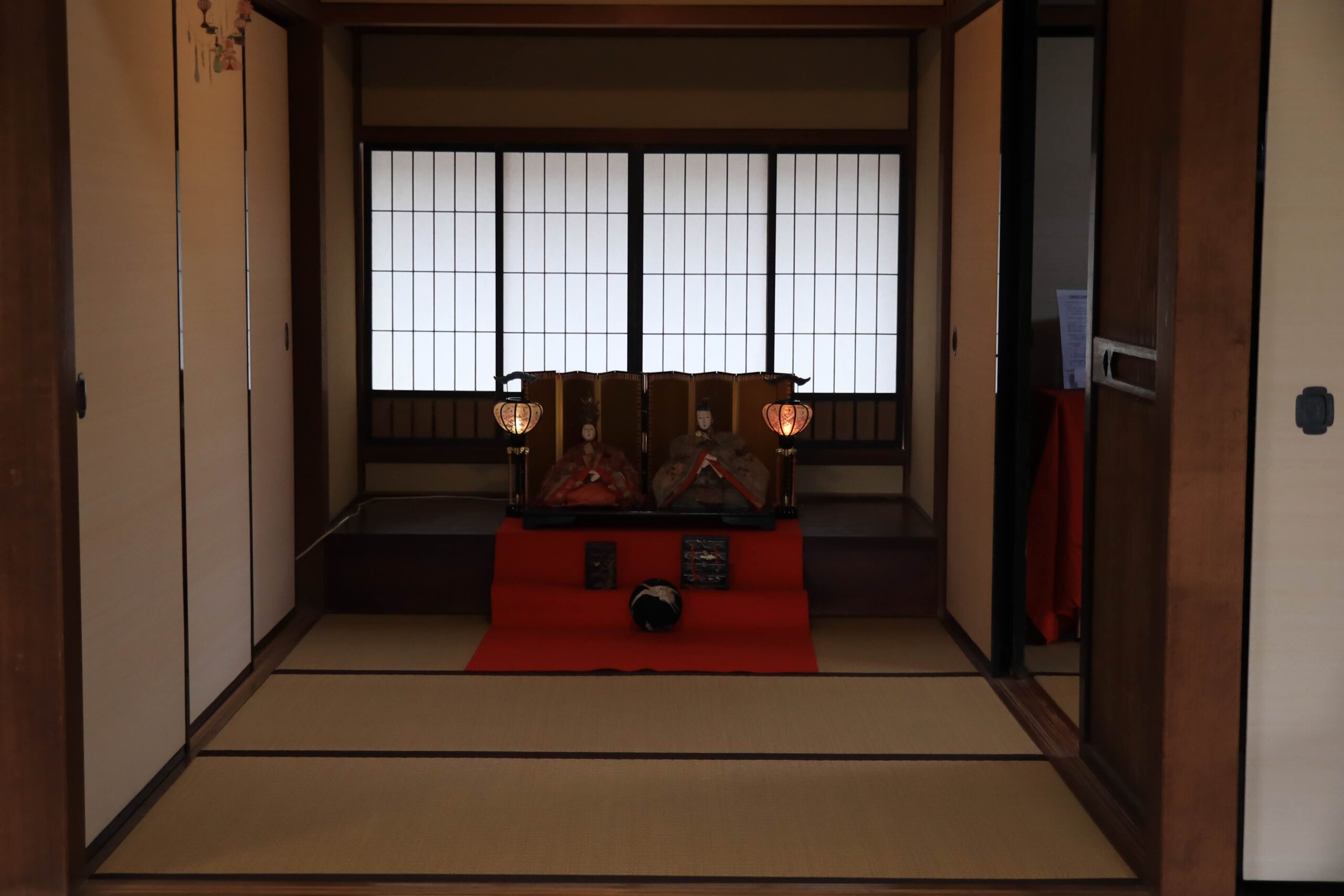 Hina dolls displayed in a traditional Japanese tatami room with shoji screens