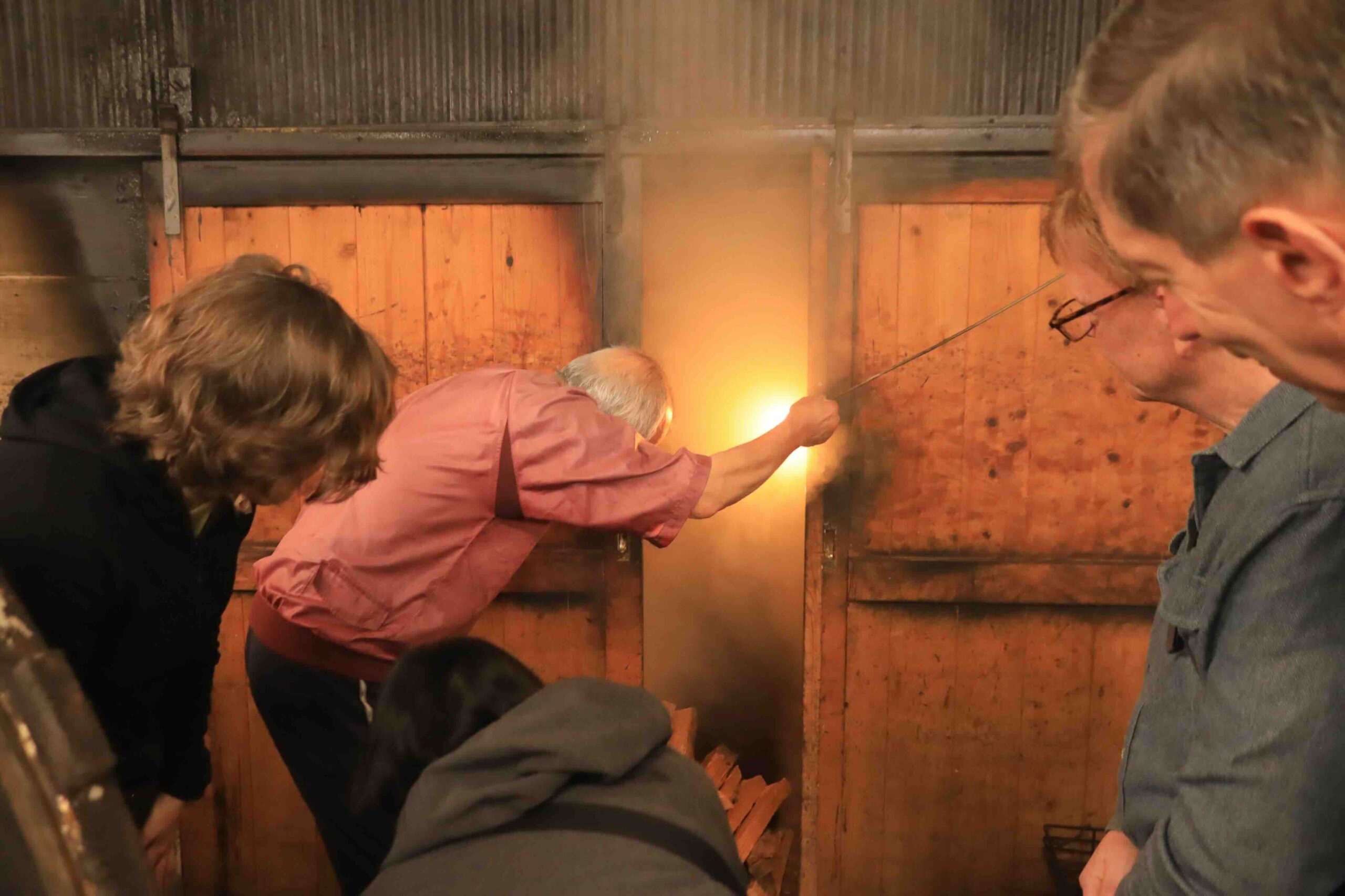 Guests looking into the smoking furnace at Hamayoshiya