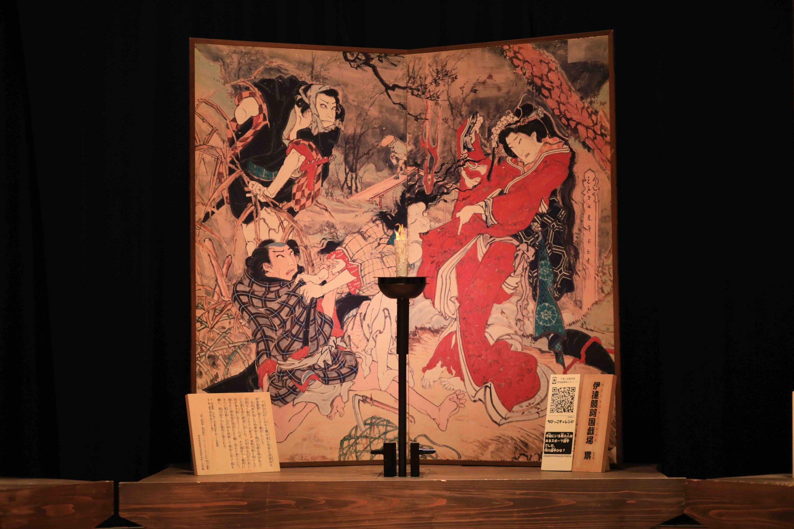 Close-up of an Ekin folding screen painting showing dramatic kabuki scene with samurai and female figure in red