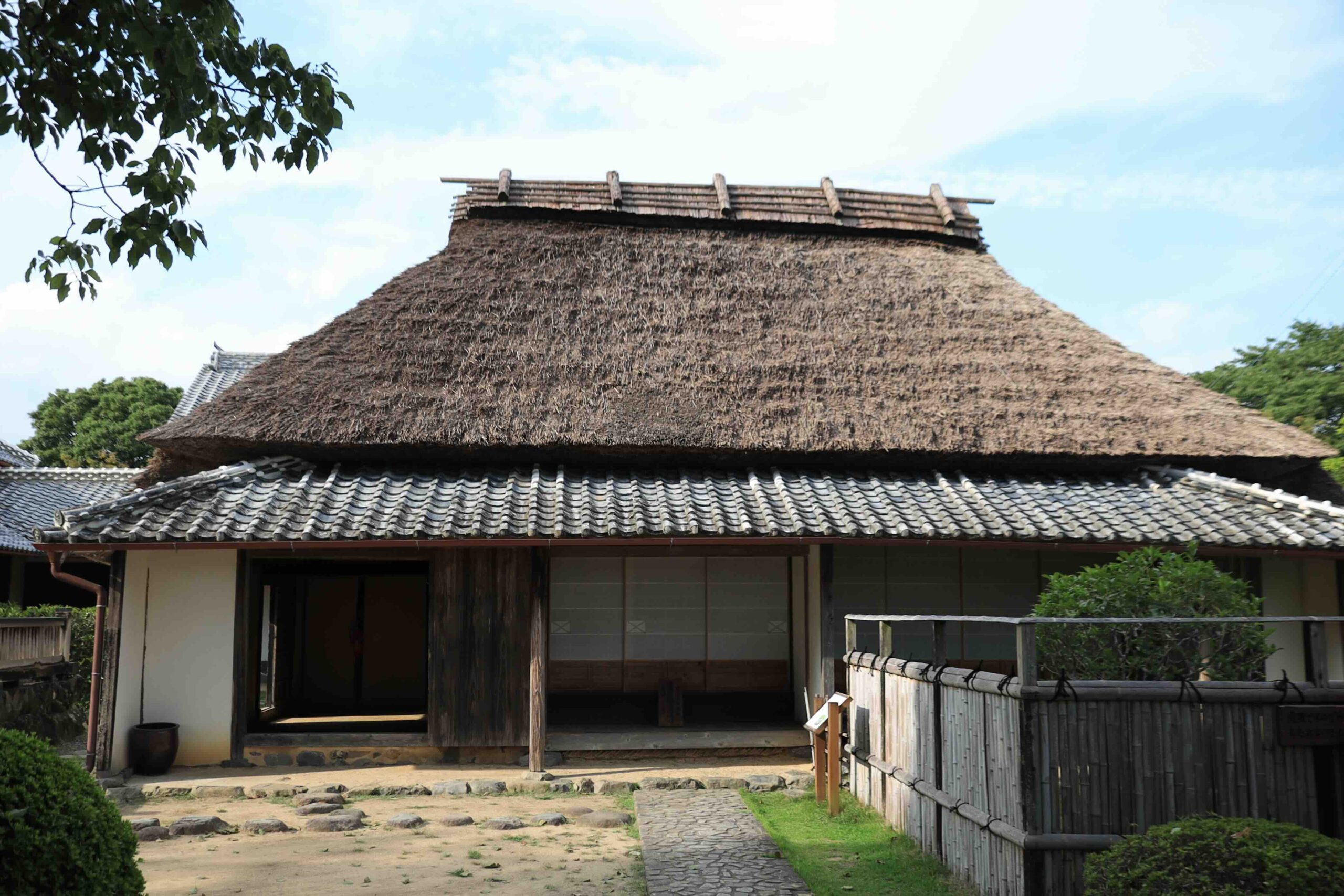 Front view of Iwasaki Yataro birthplace thatched farmhouse with open entrance in Aki City