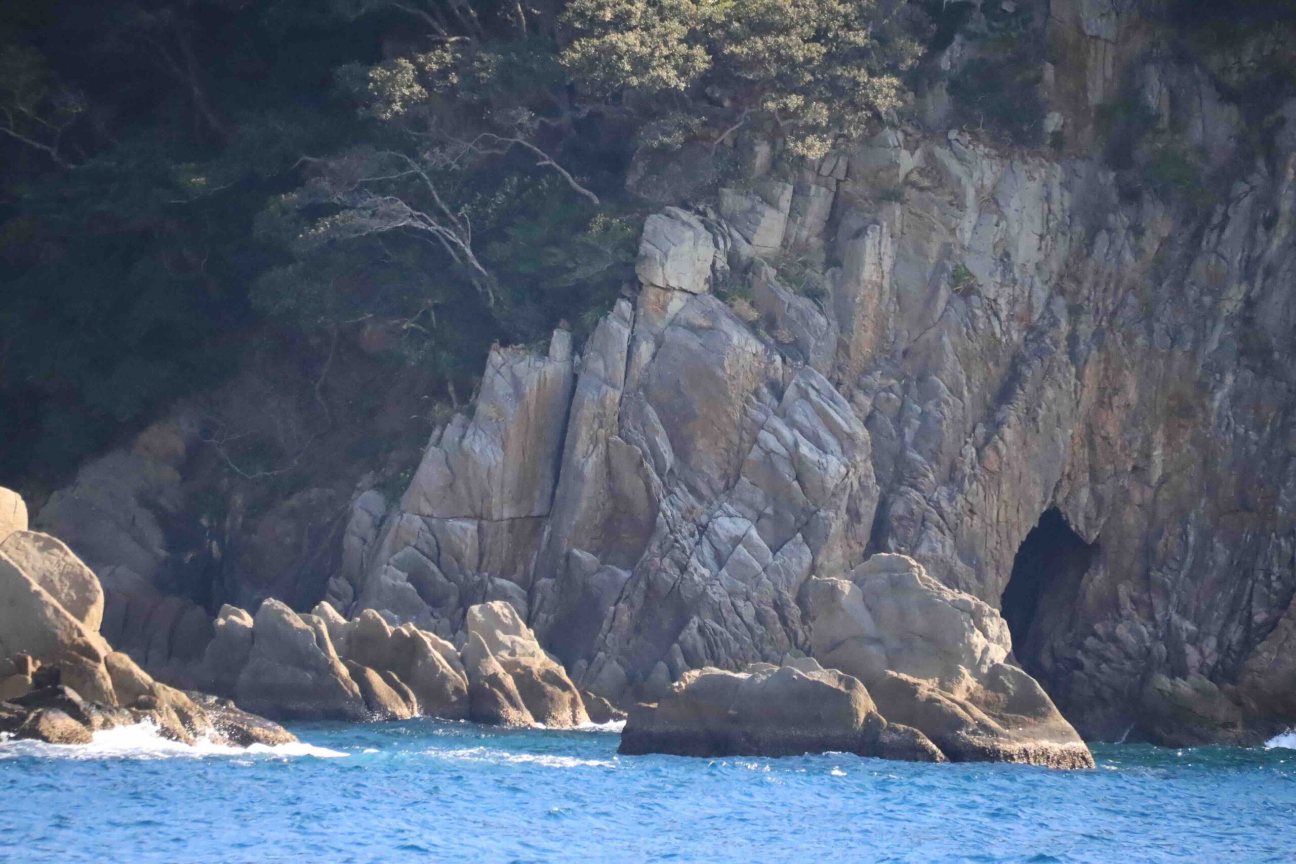 Rocky cliffs and sea cave formations along the coastline near Matsuo Fishing Harbor