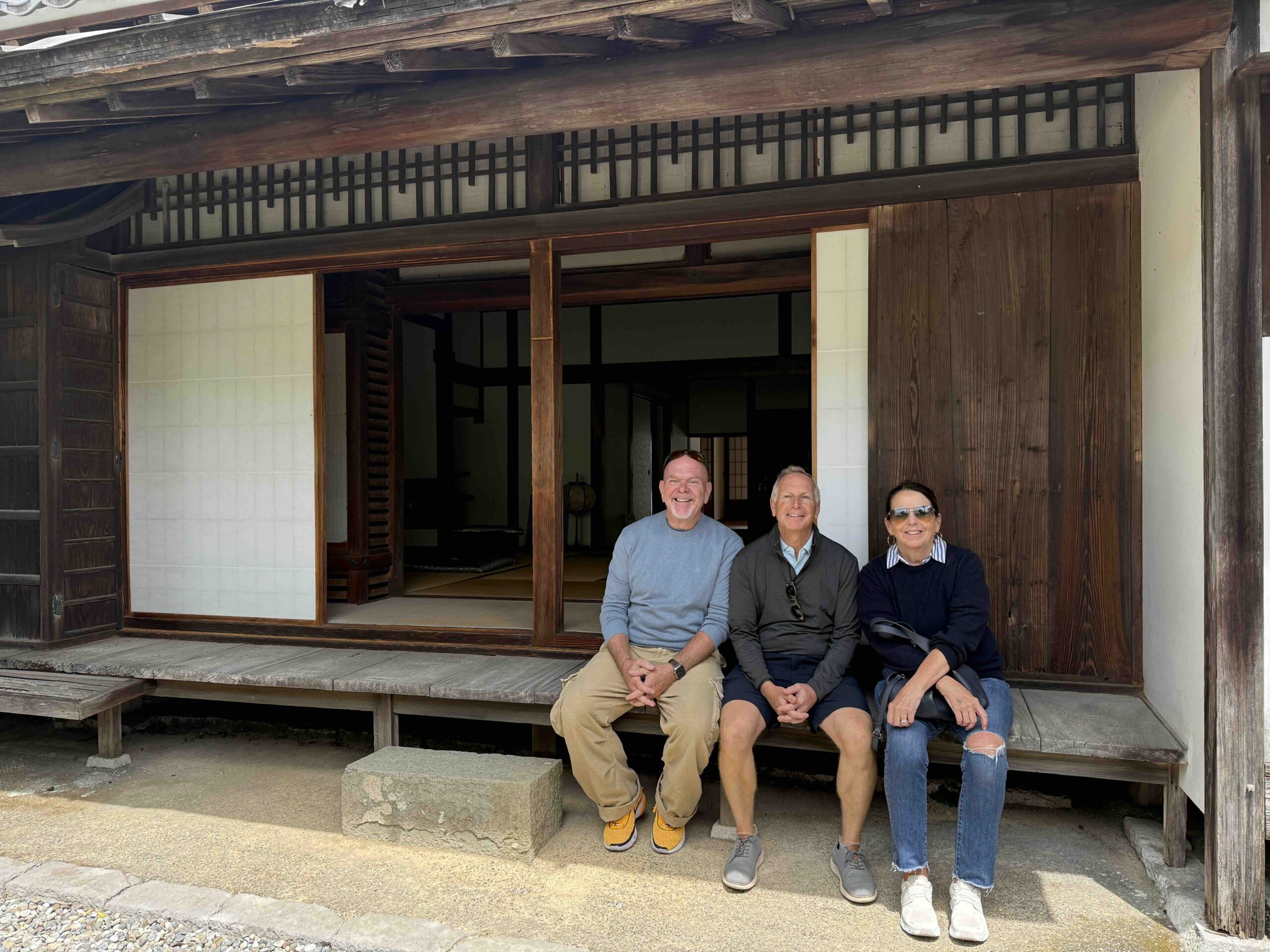 Guests sitting on the wooden veranda of a traditional samurai residence in Okawasuji