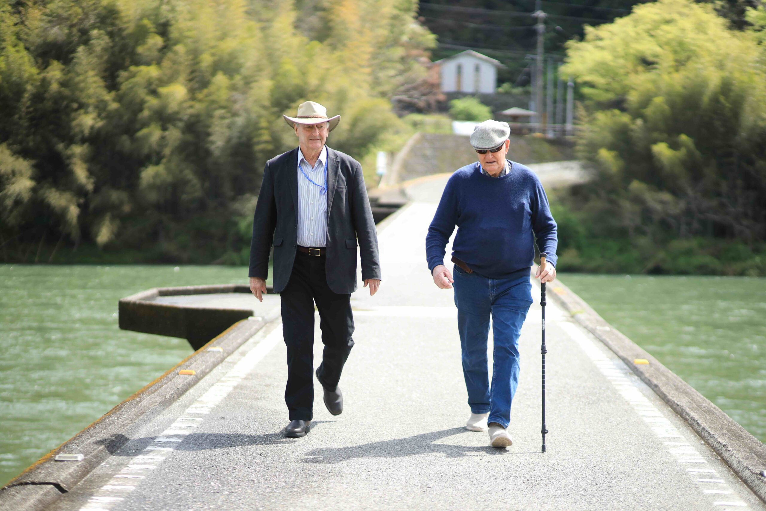 Two men walking across Nagoya Chinkabashi low-water bridge over the Niyodo River in Kochi