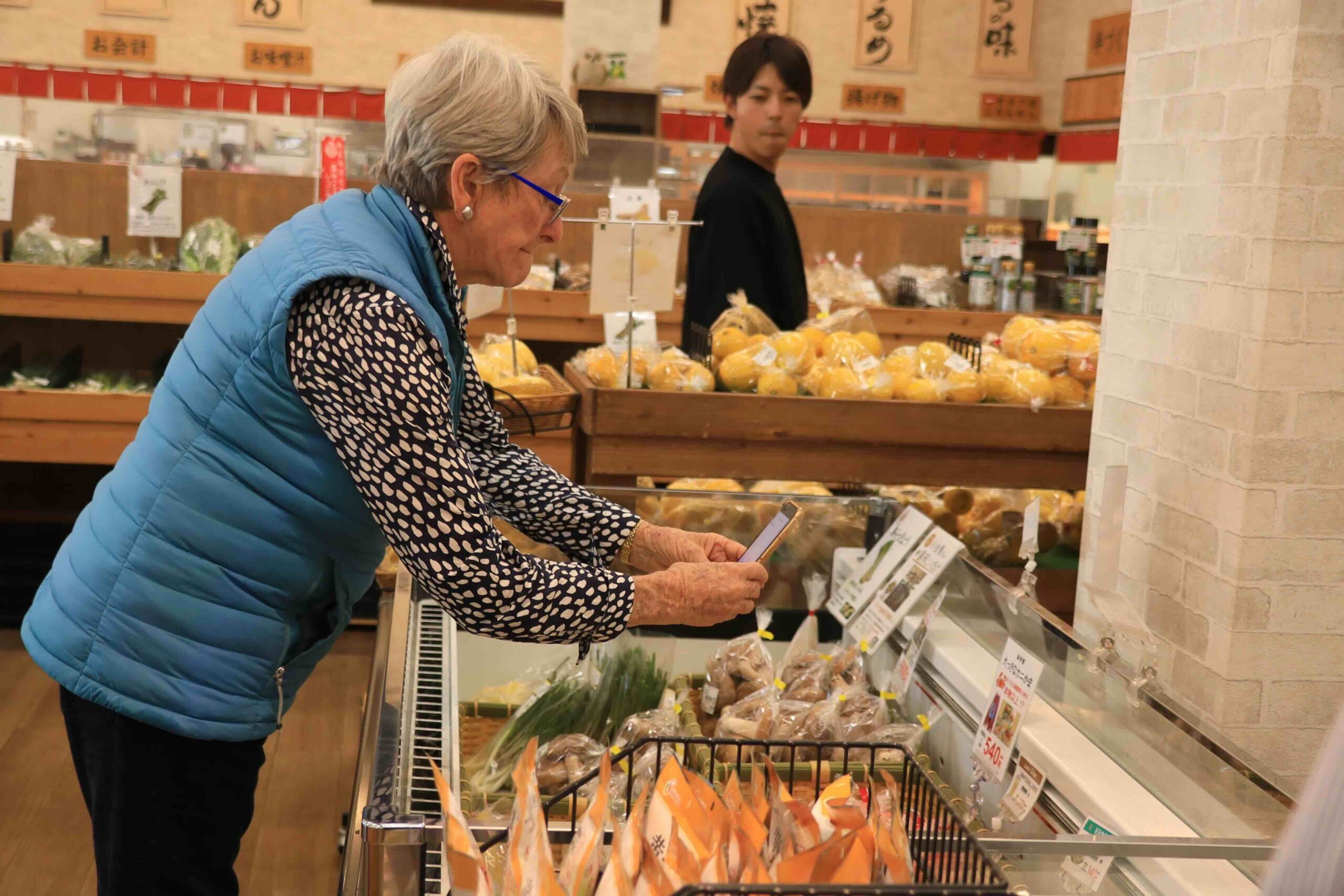 A visitor from Australia browsing fresh local produce at a market in Tosa City, Kochi