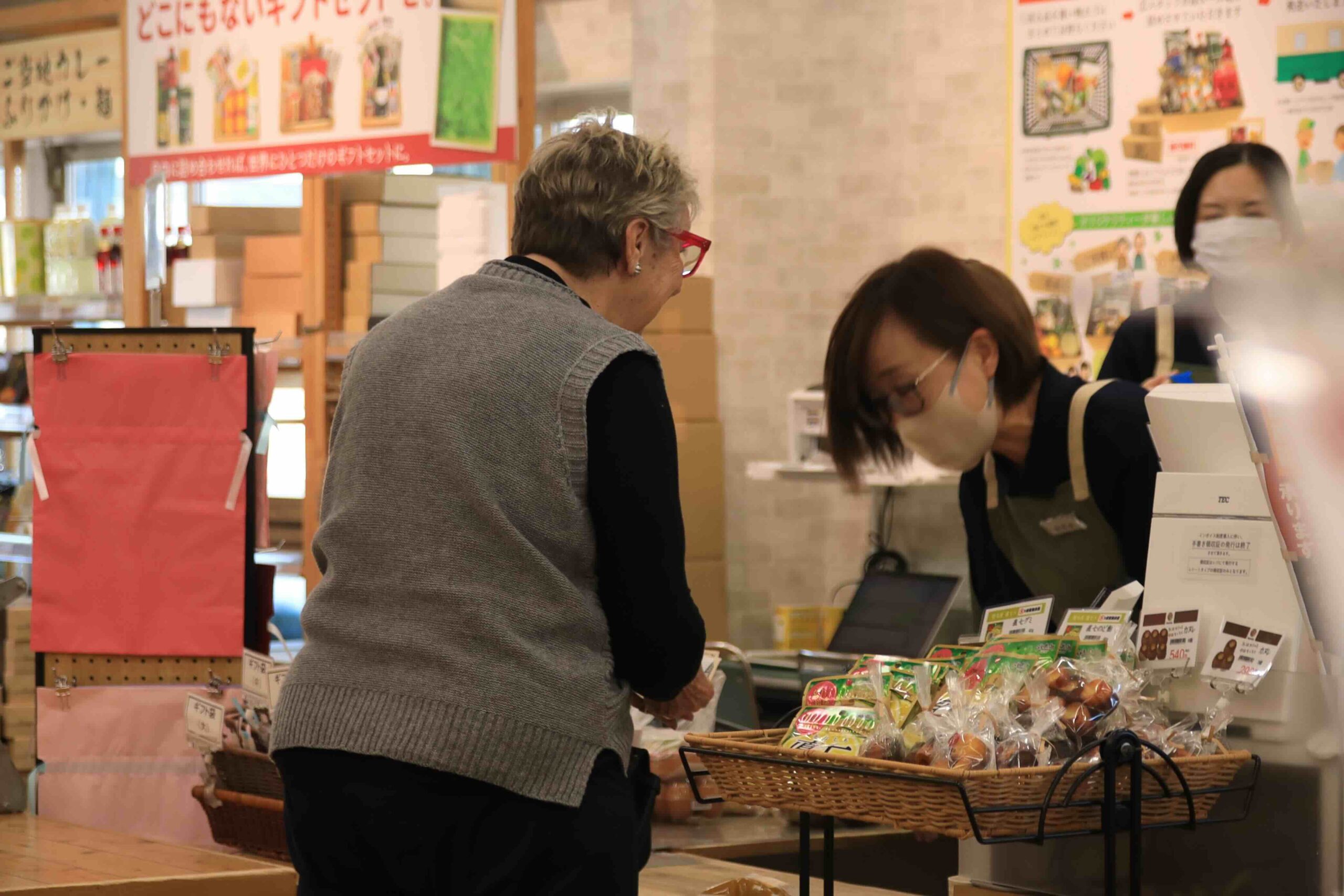 A visitor purchasing local sweets at a shop counter in Tosa City, Kochi
