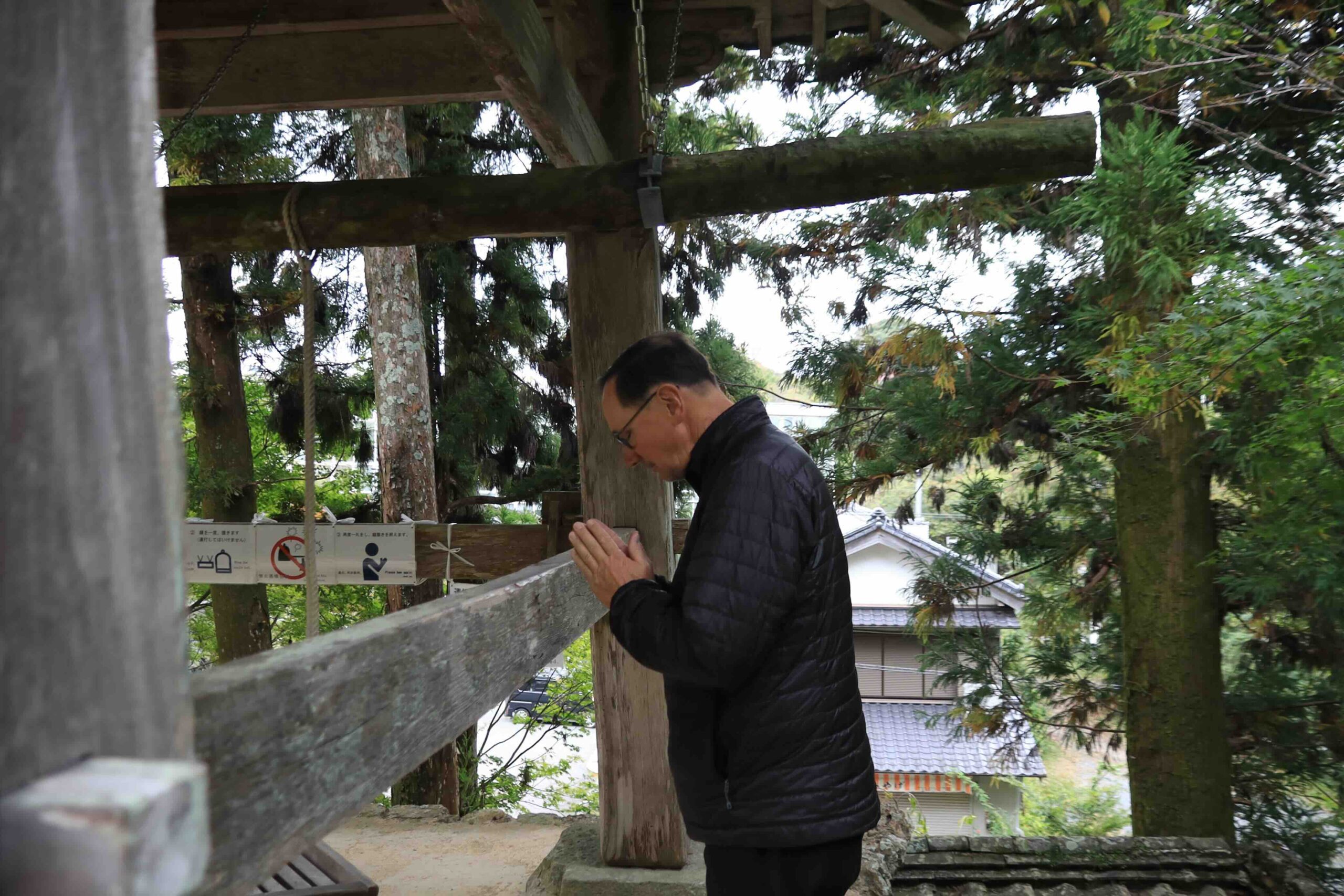 Temple staff writing a goshuin calligraphy stamp in a visitor's book at Chikurinji Temple