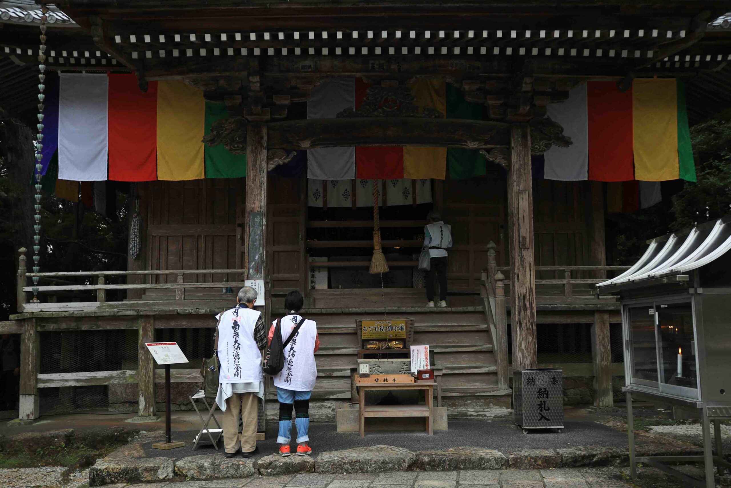Buddhist pilgrims in white robes praying at the main hall of Chikurinji Temple